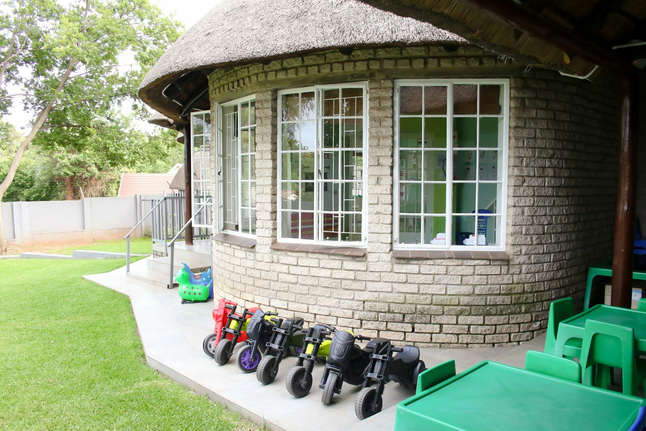 Balance bikes lined up outside the thatched-roof school