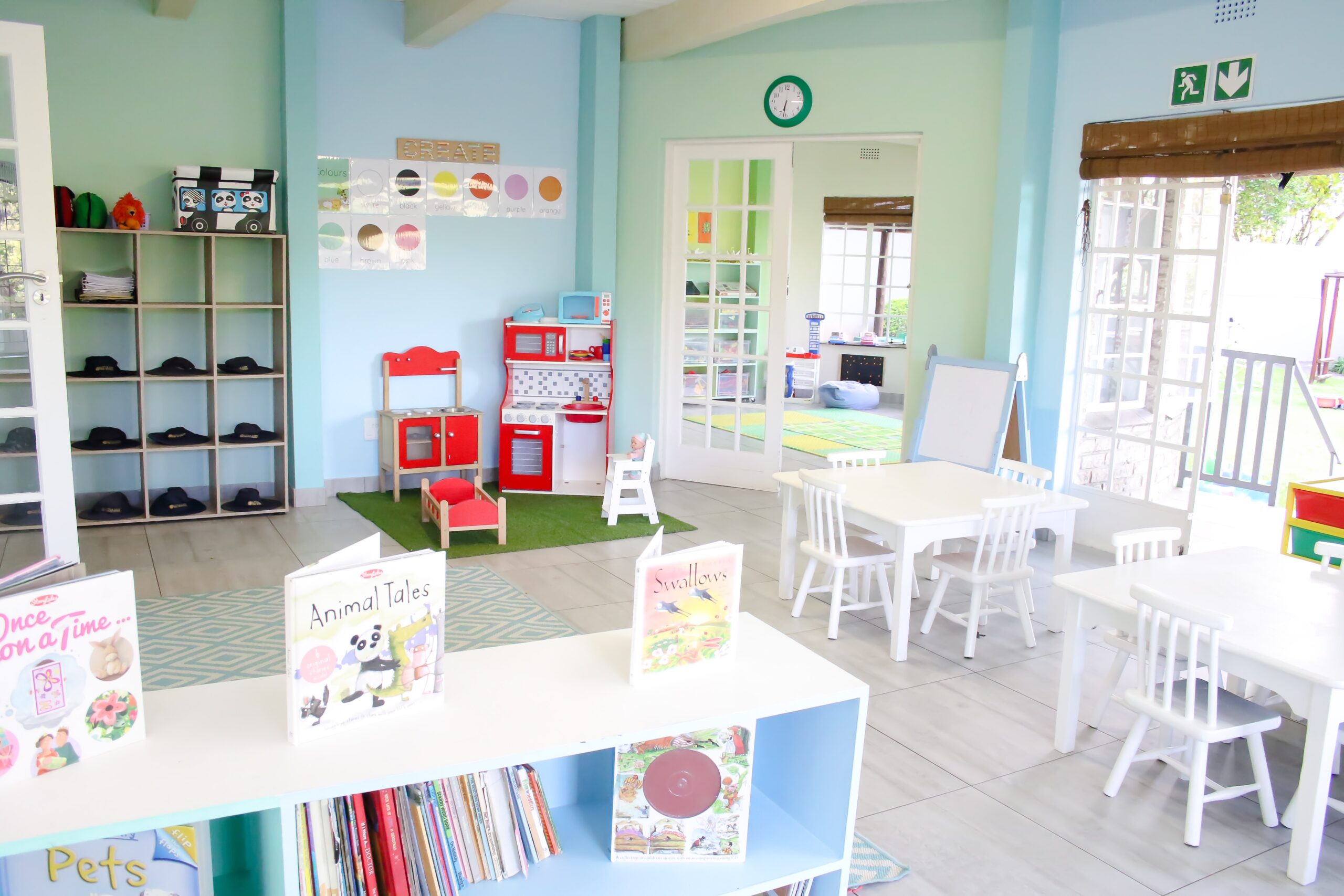 Bright classroom with picture books, a play kitchen and child-sized tables