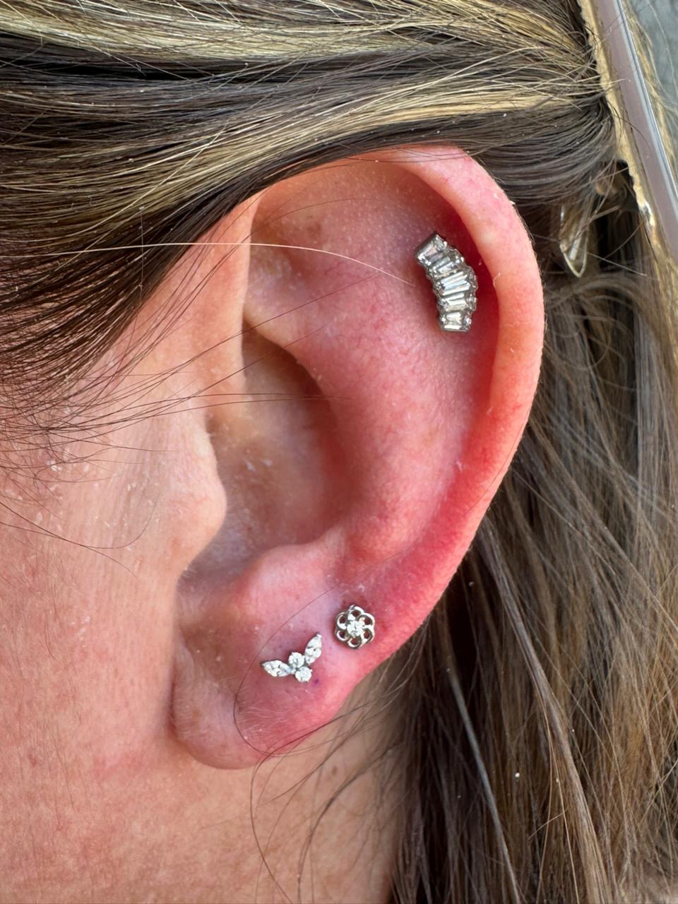 Healed helix and lobe piercings with flower and cluster studs by Ray