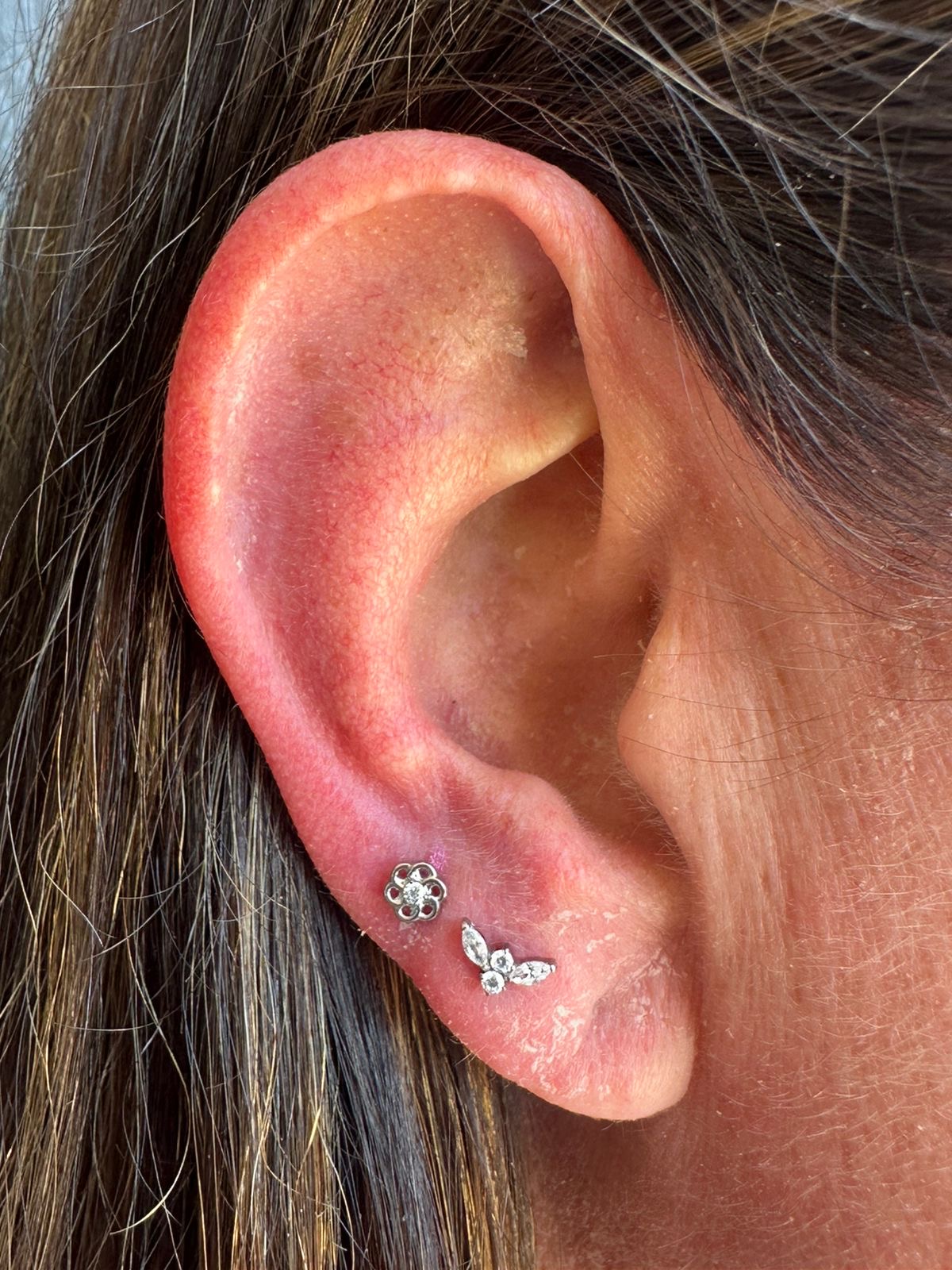 Healed lobe piercings with a flower and leaf cluster by Ray