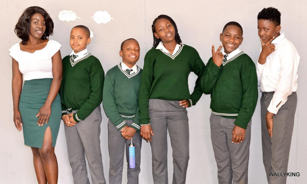 A group of Winners Academy high-school pupils in uniform with their teacher