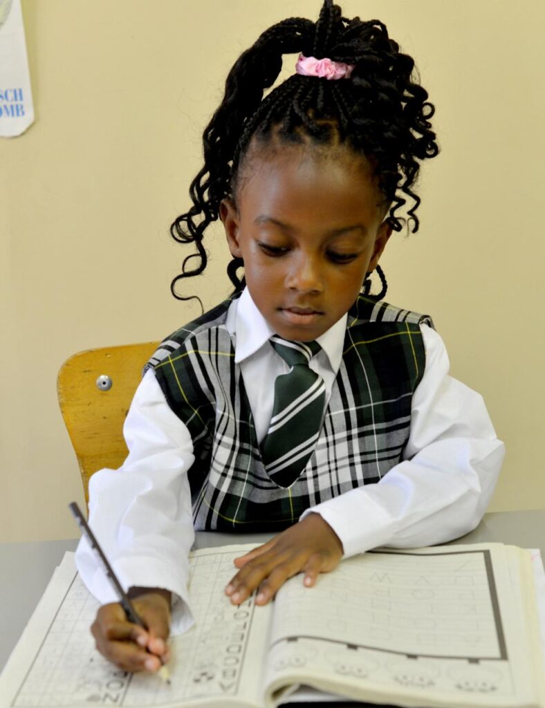 A Winners Academy primary-school pupil concentrating at her desk during a writing lesson